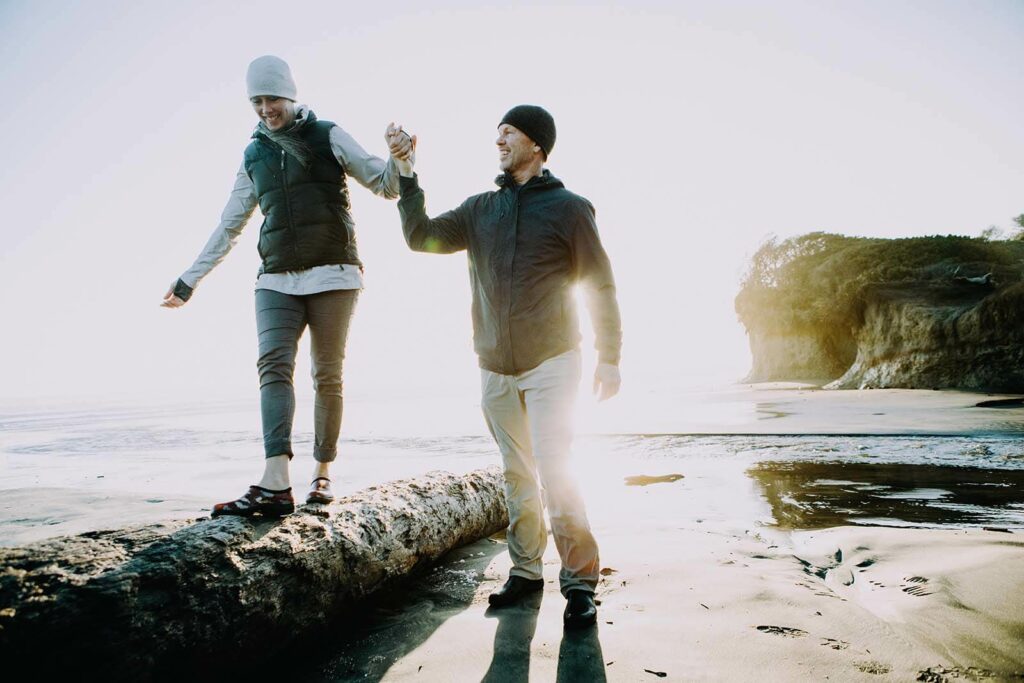 Couple enjoy a walk on the beach - Via Wealth